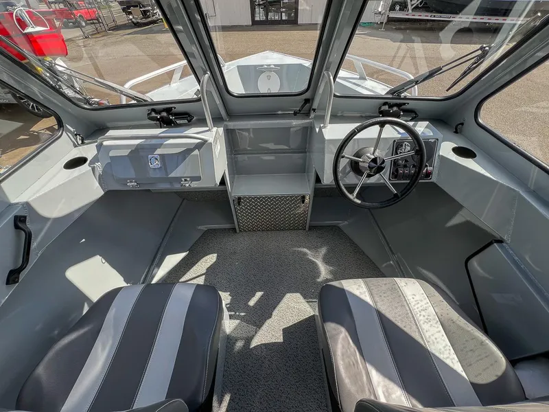 Slide: The Image of Interior of 2024 Hewescraft 200 Sportsman boat, featuring steering wheel and seating. - 8