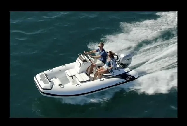 Slide: The Image of 2024 Walker Bay Gen 13 LTE inflatable boat in showroom, featuring sleek design and modern seating. - 2