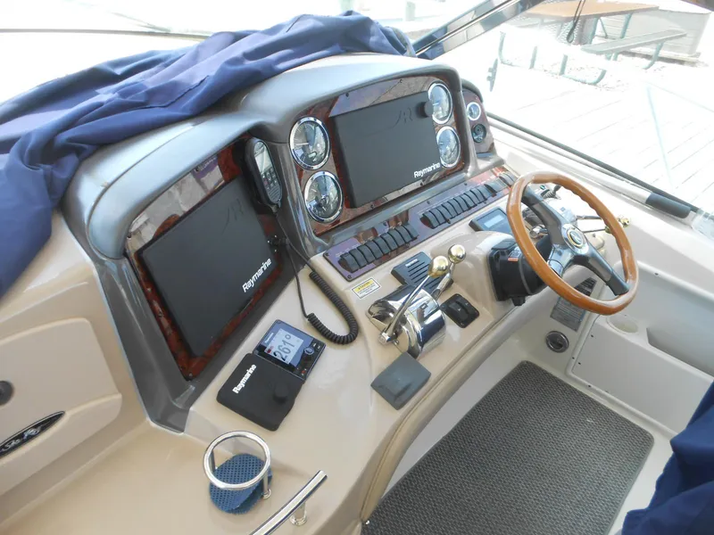 Slide: The Image of 2004 Sea Ray 420 Sundancer helm with Raymarine electronics and wooden steering wheel. - 20