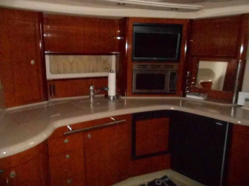 Slide: The Image of 2004 Sea Ray 420 Sundancer yacht kitchen with wood cabinetry and modern appliances. - 22