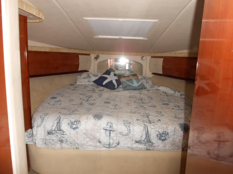 Slide: The Image of Interior cabin of 2004 Sea Ray 420 Sundancer with nautical-themed bedding. - 23