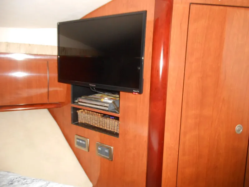 Slide: The Image of Flat-screen TV and storage shelves in the cabin of a 2004 Sea Ray 420 Sundancer yacht. - 24