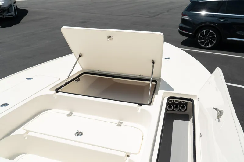 Slide: The Image of 2025 ShearWater X22 boat with open storage compartments in a parking lot. - 15