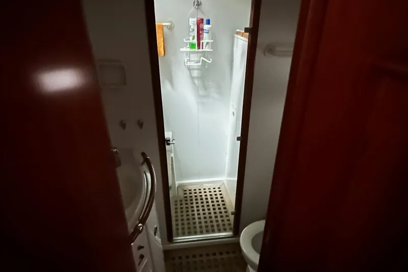 Slide: The Image of Bathroom interior of a 2001 Lagoon 380 catamaran, featuring a shower and toilet. - 13