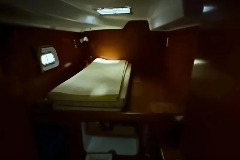 Slide: The Image of Cozy cabin interior of 2001 Lagoon 380 catamaran with single bed and porthole window. - 14