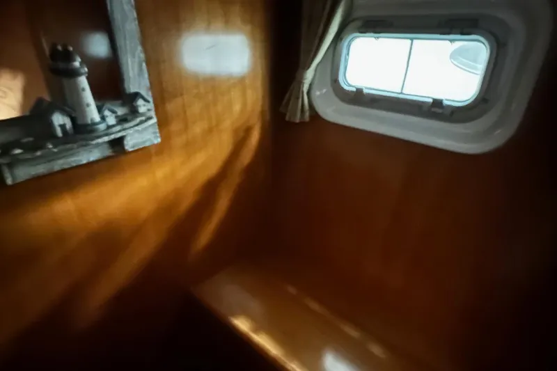 Slide: The Image of Interior of 2001 Lagoon 380 yacht with wooden paneling and a small window. - 17
