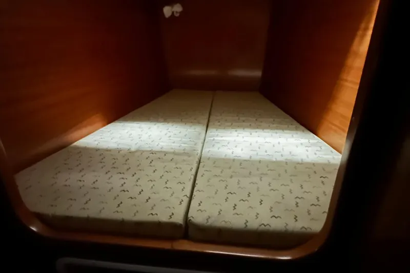 Slide: The Image of Cabin interior of 2001 Lagoon 380 catamaran with twin mattresses and wooden finish. - 18