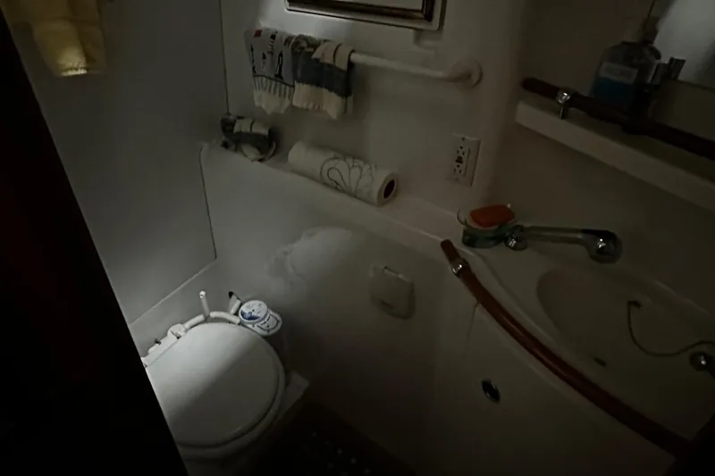 Slide: The Image of Compact bathroom in a 2001 Lagoon 380 catamaran, featuring a toilet and sink. - 20