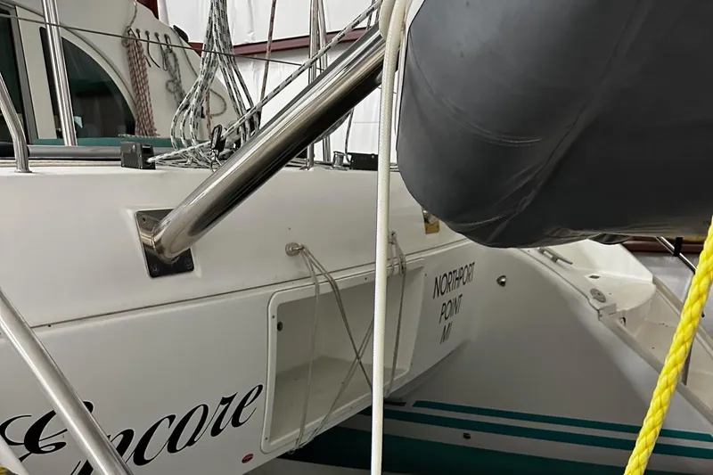 Slide: The Image of 2001 Lagoon 380 catamaran docked, featuring sleek design and visible rigging. - 22