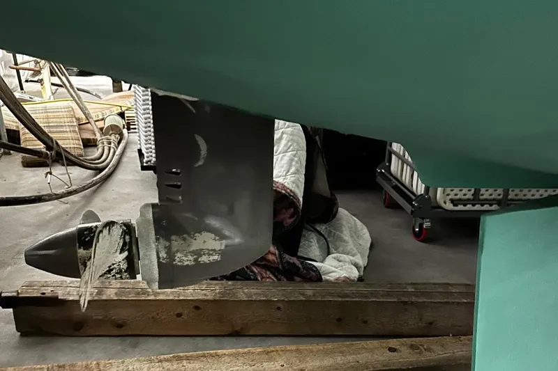 Slide: The Image of Propeller and rudder of a 2001 Lagoon 380 catamaran in a workshop setting. - 25