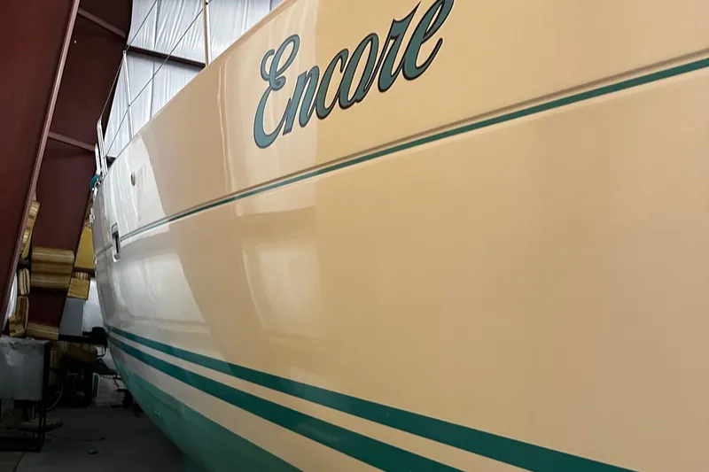 Slide: The Image of 2001 Lagoon 380 catamaran named "Encore" in storage, showcasing sleek design and vibrant colors. - 4