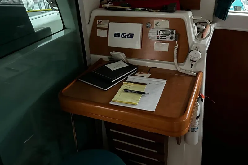 Slide: The Image of Navigation station inside a 2001 Lagoon 380 catamaran with B&G equipment and documents. - 9