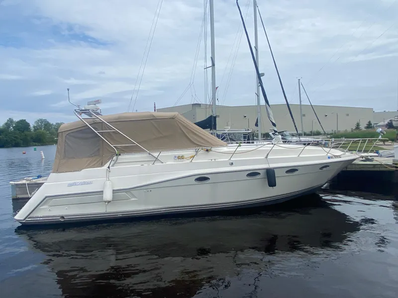 The Image of 1993 Cruisers 3675 yacht docked at marina with beige canopy. - 0
