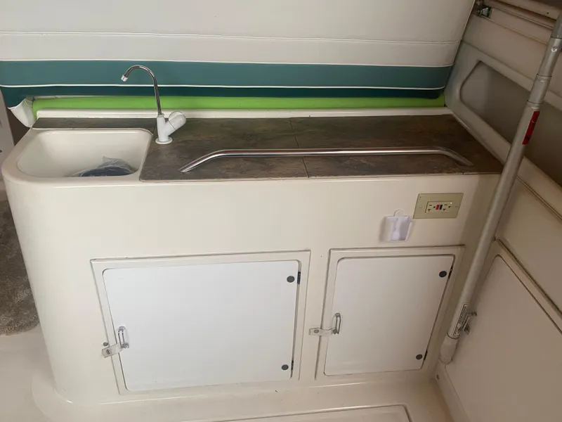 Slide: The Image of 1993 Cruisers 3675 boat kitchenette with sink, faucet, and storage cabinets. - 11