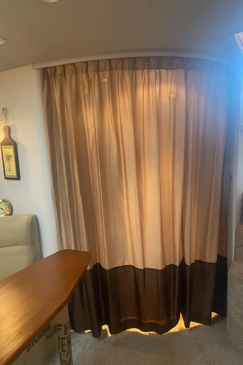 Slide: The Image of Interior of a 1993 Cruisers 3675 boat with beige and brown curtains. - 23