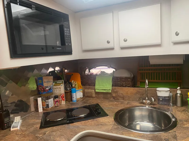 Slide: The Image of 1993 Cruisers 3675 boat kitchen with microwave, stove, and sink. - 13