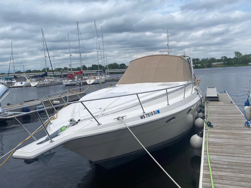 Slide: The Image of 1993 Cruisers 3675 yacht docked at a marina on a cloudy day. - 3