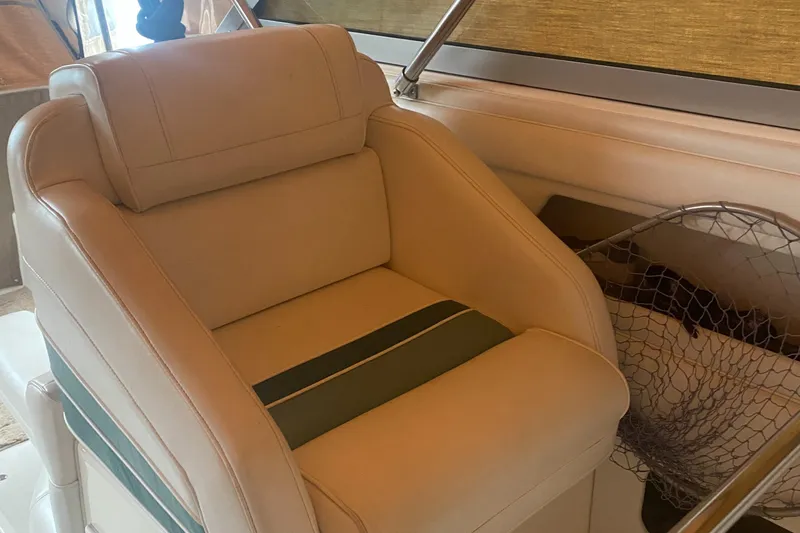 Slide: The Image of Captain's chair on a 1993 Cruisers 3675 yacht, featuring beige upholstery and green accents. - 8
