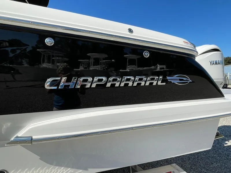 Slide: The Image of 2024 Chaparral 270 OSX boat with sleek black and white design. - 2