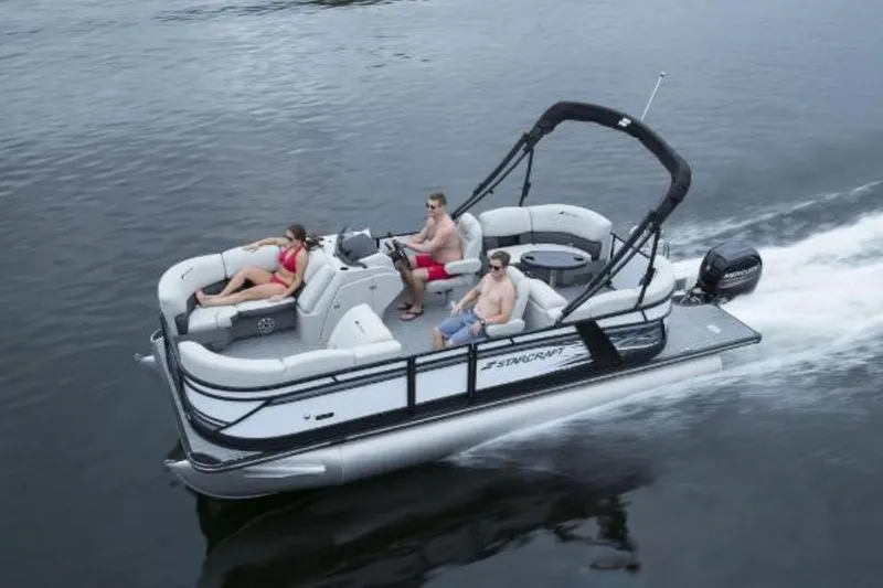 Slide: The Image of 2025 Starcraft SLS 1 pontoon boat cruising on water with passengers relaxing. - 7