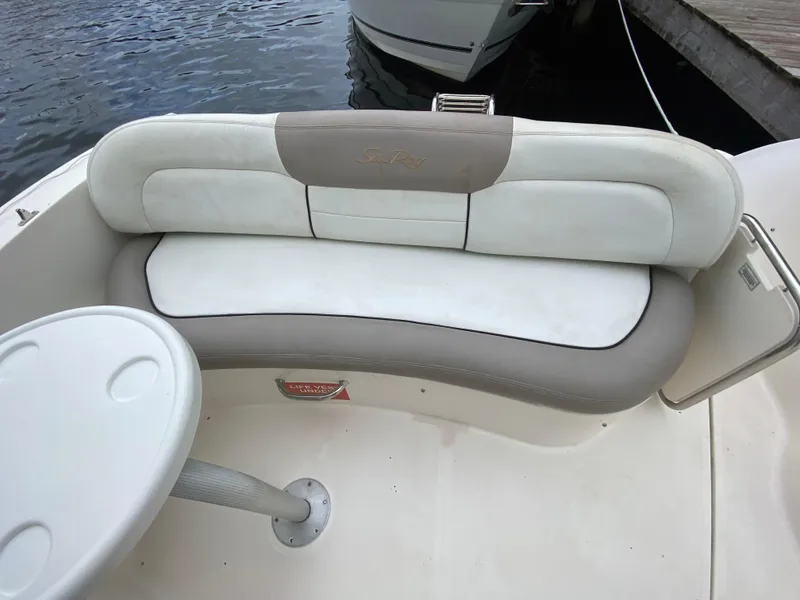 Slide: The Image of 2008 Sea Ray 310 Sundancer boat seating area with table, docked by the water. - 11