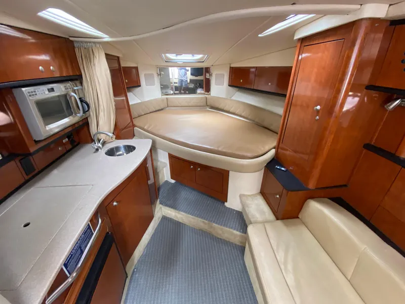 Slide: The Image of 2008 Sea Ray 310 Sundancer cabin with kitchenette, bed, and seating area. - 18