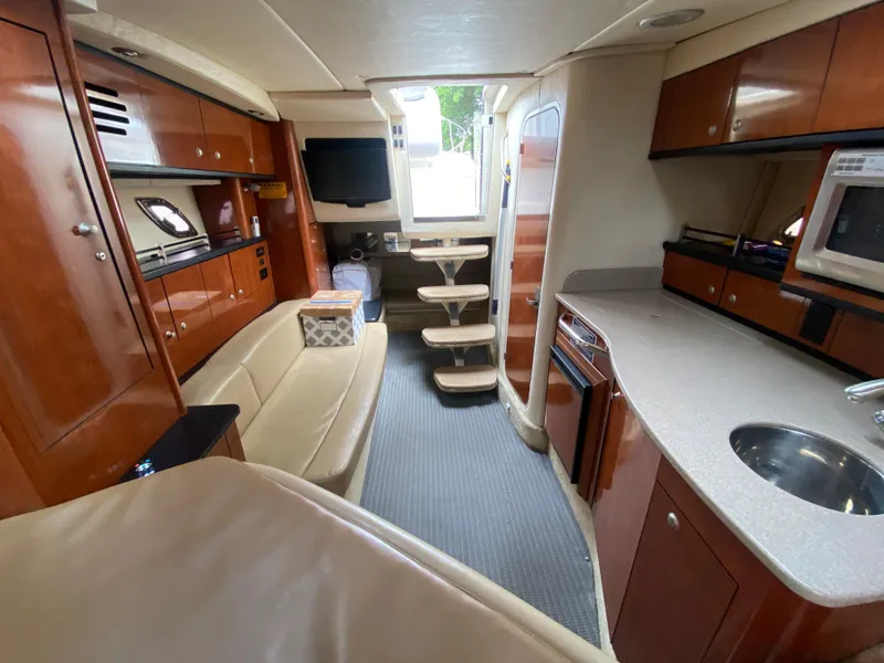 Slide: The Image of Interior of 2008 Sea Ray 310 Sundancer yacht with modern kitchen and seating area. - 19
