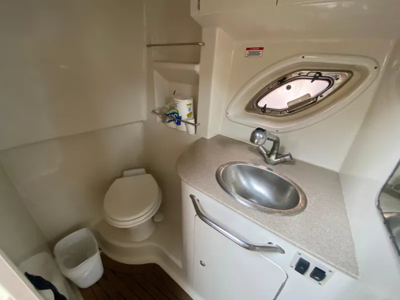 Slide: The Image of 2008 Sea Ray 310 Sundancer bathroom with sink, toilet, and porthole window. - 20