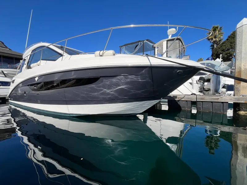 Slide: The Image of 2018 Sea Ray Sundancer 350 yacht docked, reflecting on calm water under clear blue sky. - 12