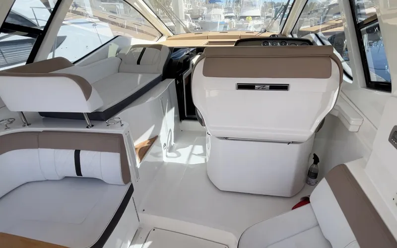 Slide: The Image of 2018 Sea Ray Sundancer 350 interior with white and beige seating, modern helm, and spacious layout. - 21