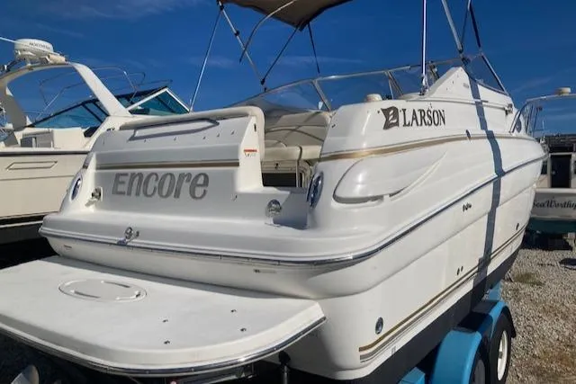 Slide: The Image of 2004 Larson 240 Cabrio boat on trailer, white exterior, sunny day. - 3