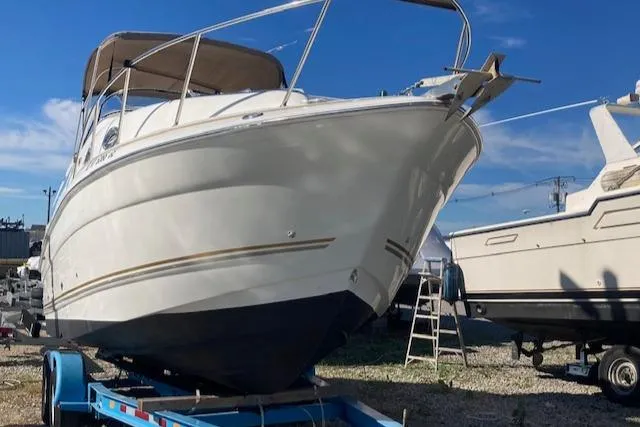 Slide: The Image of 2004 Larson 240 Cabrio boat on trailer under clear blue sky. - 4