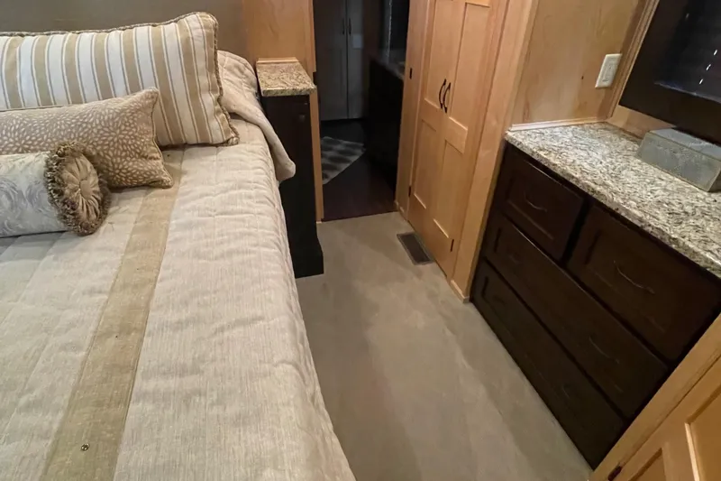 Slide: The Image of Sumerset Show Boat 2018 bedroom with bed, pillows, and wooden cabinetry. - 41
