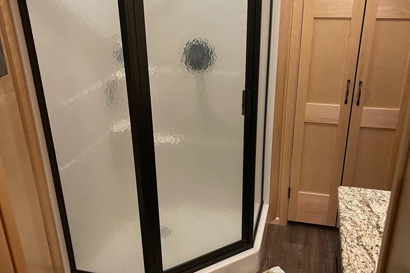 Slide: The Image of 2018 Sumerset Show Boat bathroom with frosted glass shower and wooden cabinets. - 45