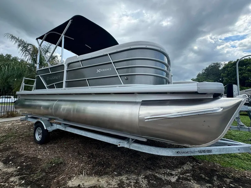 The Image of 2024 Sweetwater 2086 CX pontoon boat on a trailer under cloudy skies. - 0