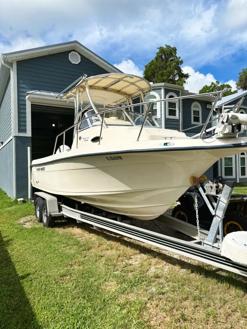 Slide: The Image of 2005 Key West 2300 Walkaround boat on a trailer in front of a house. - 6