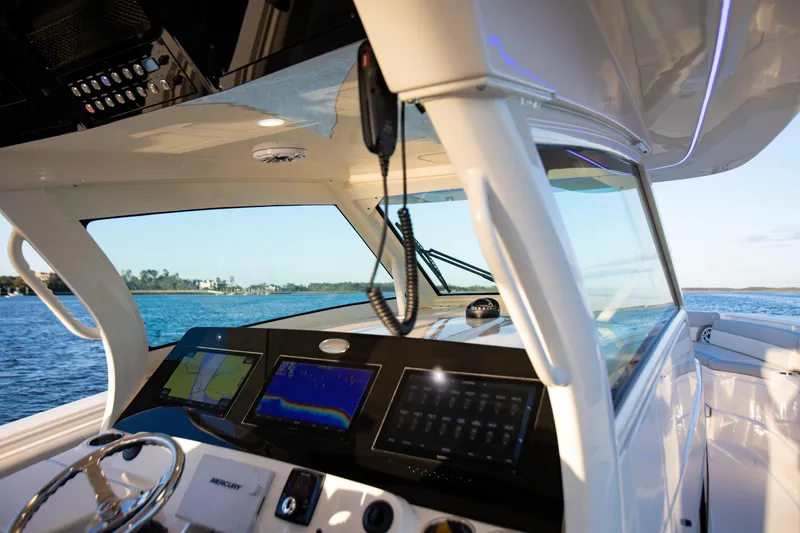 Slide: The Image of Helm of 2026 Scout 425 LXF boat with advanced navigation displays on open water. - 16