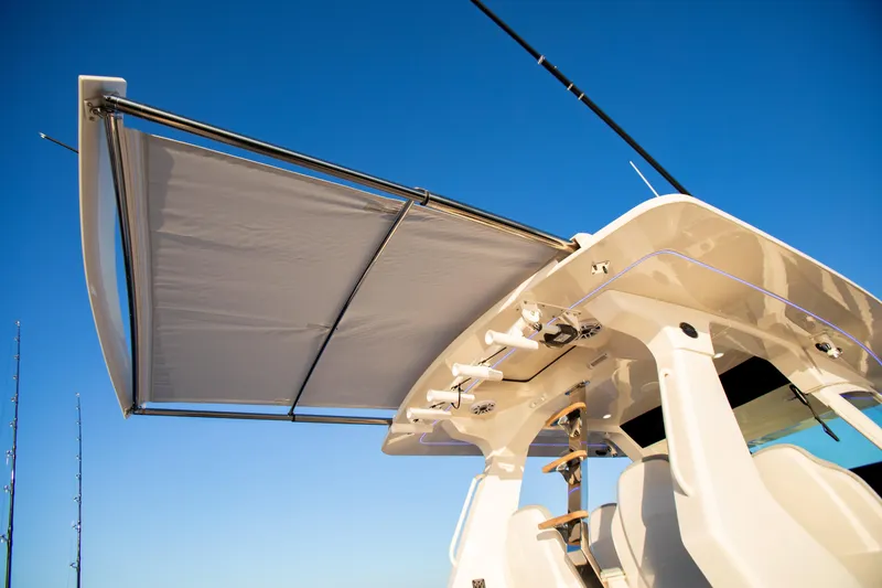 Slide: The Image of 2026 Scout 425 LXF boat with extended sunshade under clear blue sky. - 18