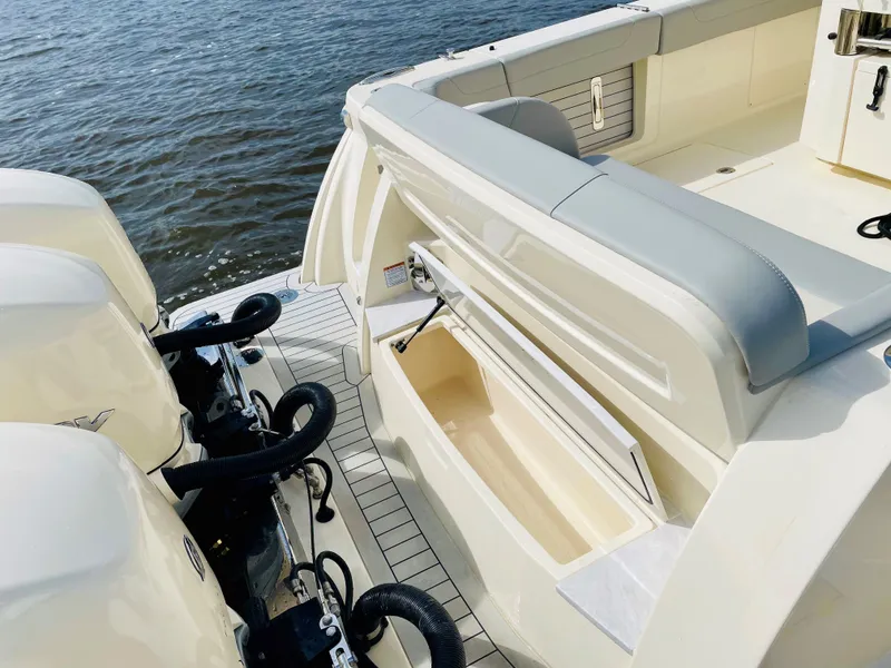 Slide: The Image of 2026 Scout 425 LXF boat with open storage compartment and dual outboard engines. - 23