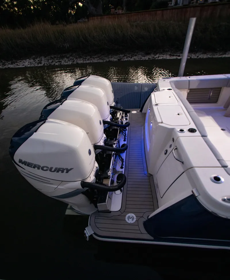 Slide: The Image of 2026 Scout 425 LXF boat with triple Mercury outboard engines, docked at sunset. - 26