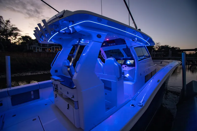 Slide: The Image of 2026 Scout 425 LXF boat with blue LED lighting at dusk. - 27