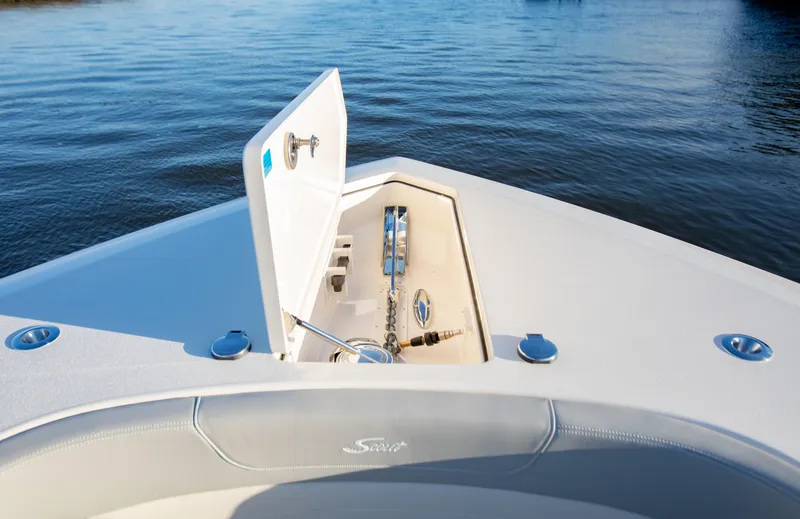 Slide: The Image of 2026 Scout 425 LXF boat anchor compartment with open hatch on calm water. - 9