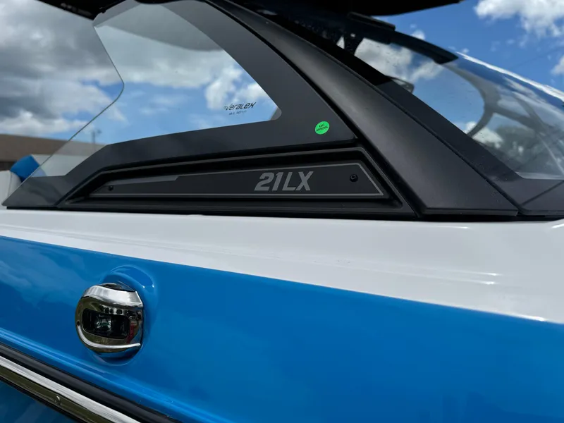 Slide: The Image of Close-up of 2024 Malibu Wakesetter 21 LX boat with blue and white exterior. - 12