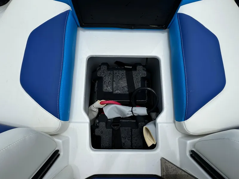 Slide: The Image of 2024 Malibu Wakesetter 21 LX battery compartment with blue and white seating. - 16