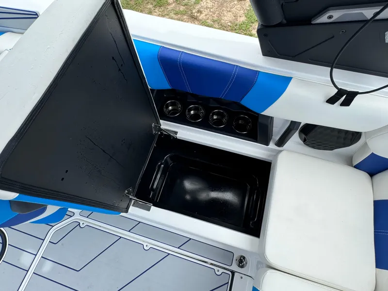 Slide: The Image of Open storage compartment in 2024 Malibu Wakesetter 21 LX boat with cup holders. - 28