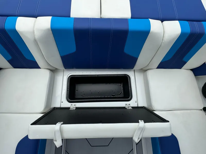 Slide: The Image of 2024 Malibu Wakesetter 21 LX boat interior with blue and white seating and storage compartment. - 29