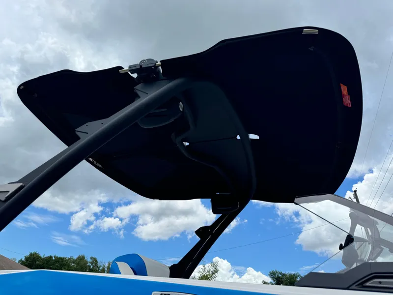 Slide: The Image of 2024 Malibu Wakesetter 21 LX boat with black wakeboard tower against a cloudy sky. - 36