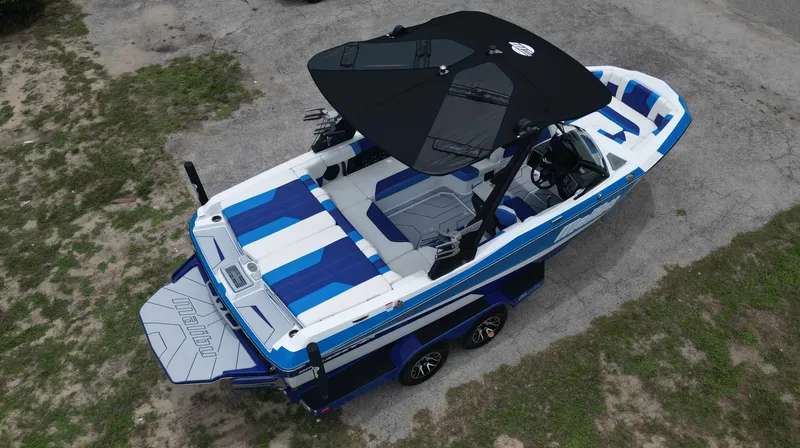 Slide: The Image of 2024 Malibu Wakesetter 21 LX boat, aerial view, blue and white design. - 4