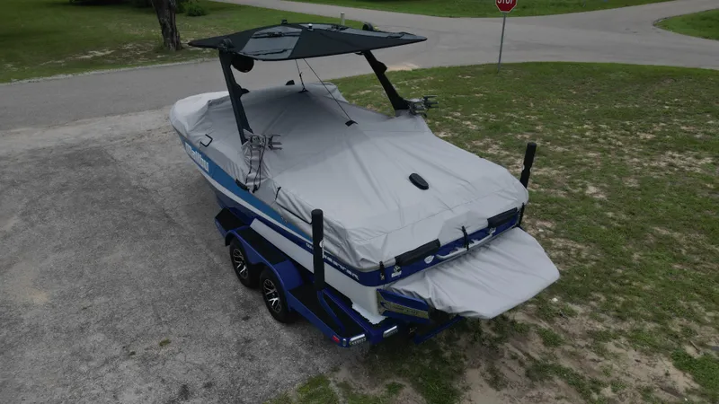 Slide: The Image of 2024 Malibu Wakesetter 21 LX boat covered on trailer in outdoor setting. - 47