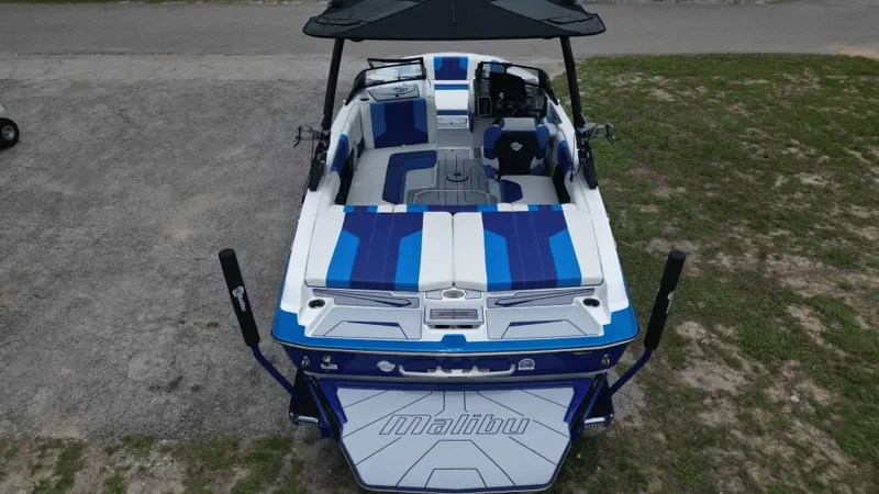 Slide: The Image of 2024 Malibu Wakesetter 21 LX boat with blue and white interior, rear view. - 6